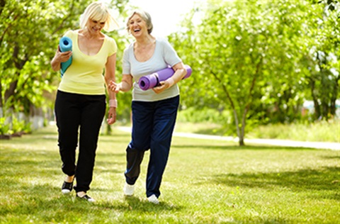 two older women walking in a park exercising